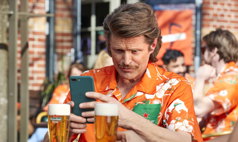 Rudi in het Holland Heineken Hemd fotografeert Heineken biertjes op het terras